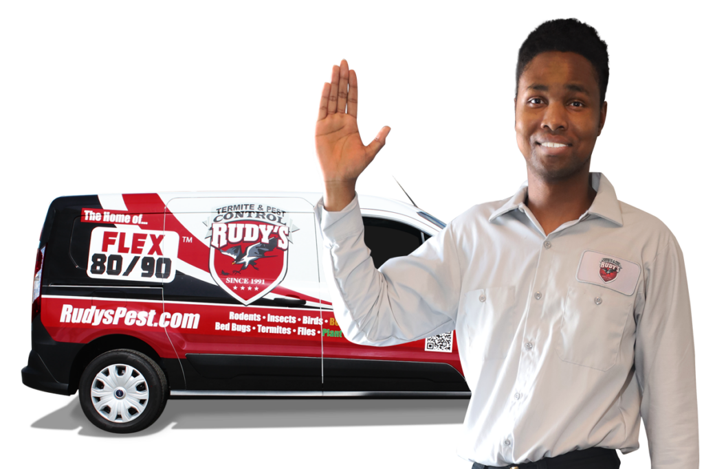 Closeup of employee waving in front of a Rudy's pest control van